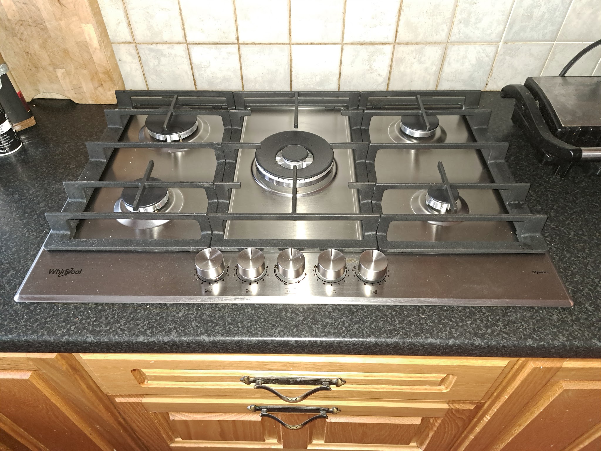 Stainless steel five-burner gas hob set into a kitchen worktop