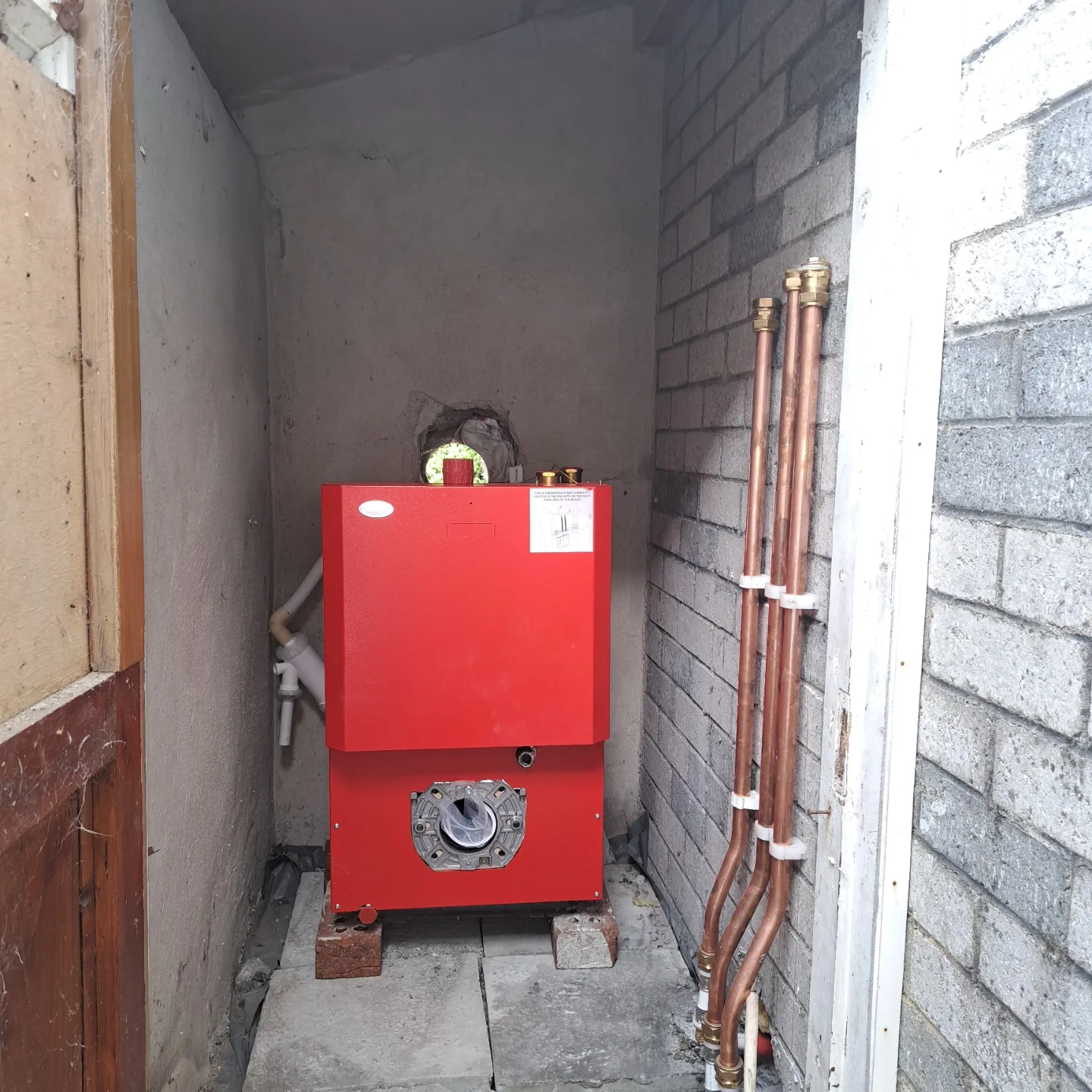 Red oil boiler in a boiler house with new copper flow and return pipes